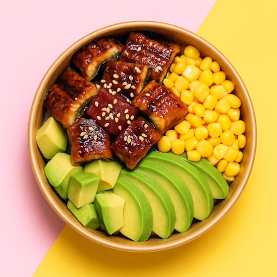 A sushi bowl with glazed eel, avocado slices, avocado cubes, and corn kernels.