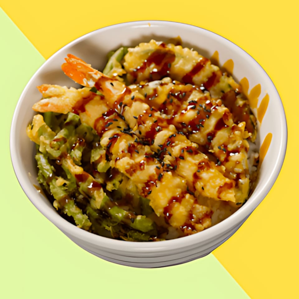 A bowl of tempura shrimp and green vegetables drizzled with sauce and sesame seeds.